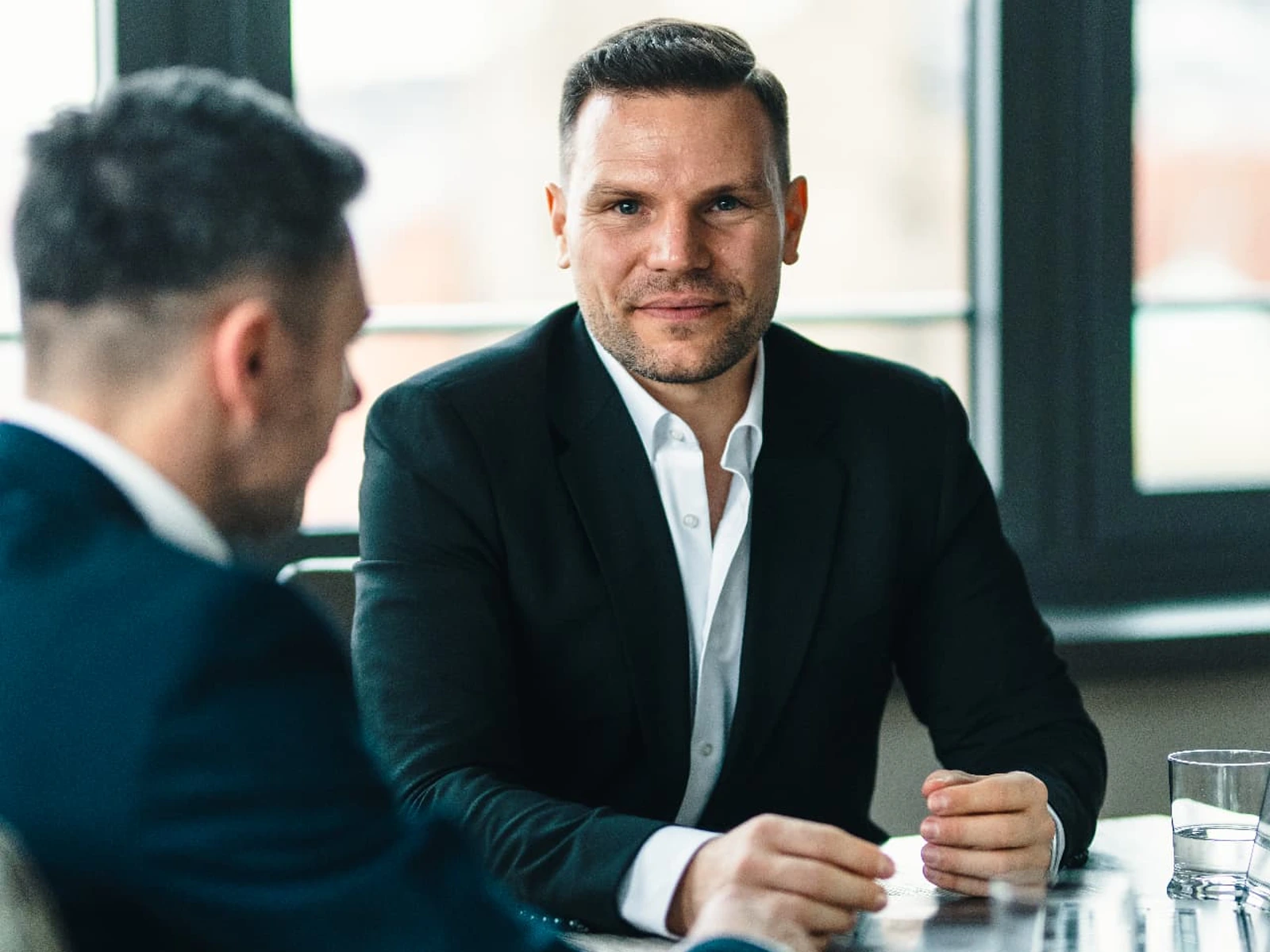 Nick van der Falk im Beratungsgespräch am Tisch