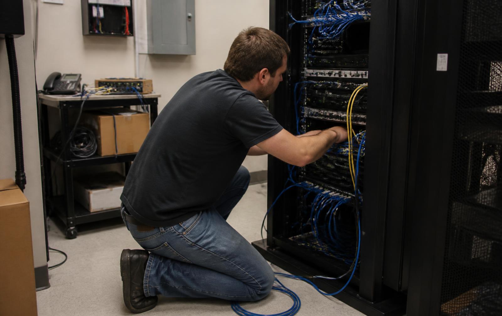 IT-Mitarbeiter verbindet Kabel im Serverschrank eines Betriebs – KI Integration