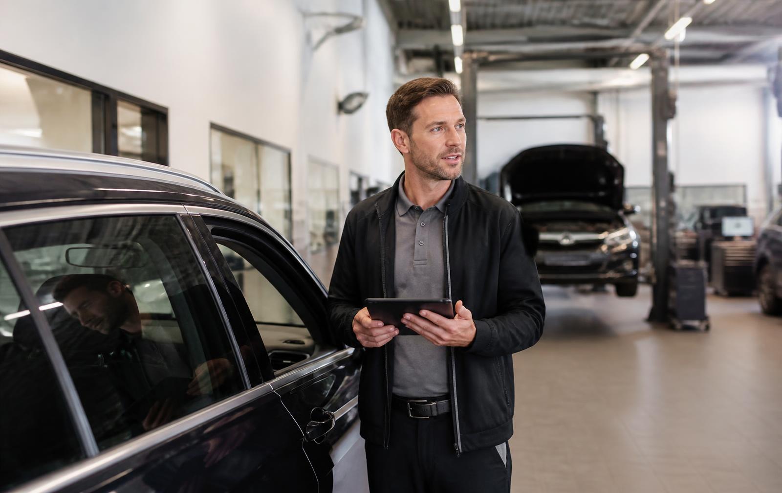Serviceberater im Autohaus mit Tablet – KI Autohaus
